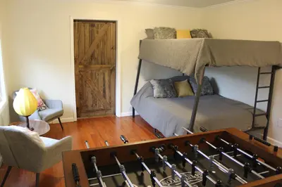 a bedroom with two bunk beds and a chair at River House on the Little Miami in Milford