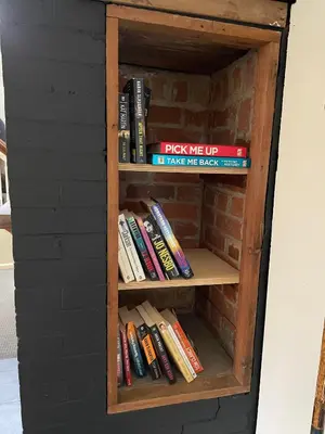 a book shelf filled with books in a brick wall at River House on the Little Miami in Milford