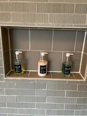 three bottles of soap on a shelf in a bathroom at River House on the Little Miami in Milford