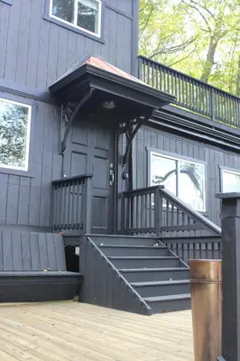a house with a black door and stairs on it at River House on the Little Miami in Milford