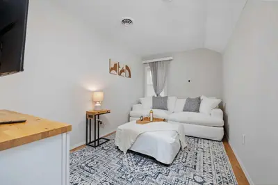 a white living room with a couch and a table at Vintage West Central Apt Walkable Free Parking! in Fort Wayne