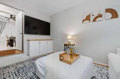 a white room with a bed and a table at Vintage West Central Apt Walkable Free Parking! in Fort Wayne