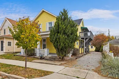 a yellow house with a tree in front of it at Vintage West Central Apt Walkable Free Parking! in Fort Wayne
