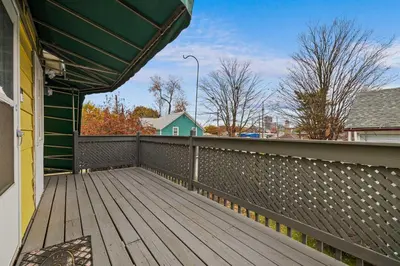 a wooden deck with awning on a house at Vintage West Central Apt Walkable Free Parking! in Fort Wayne