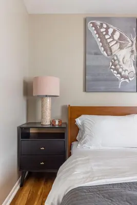 a bedroom with a bed with a butterfly painting on the wall at Heights Sweet - Libby Unit 7 in Maple Heights