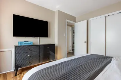 a bedroom with a bed and a tv on a wall at Heights Sweet - Libby Unit 7 in Maple Heights
