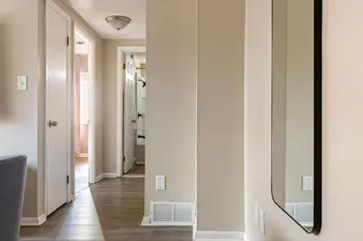 a hallway with a mirror on the wall at Heights Sweet - Libby Unit 7 in Maple Heights