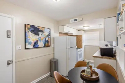 a small kitchen with a table and a refrigerator at Heights Sweet - Libby Unit 7 in Maple Heights