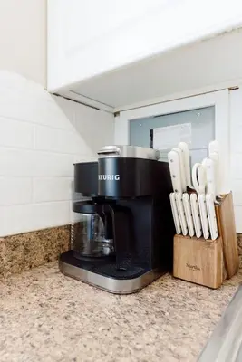 a coffee maker sitting on a counter with knives at Heights Sweet - Libby Unit 7 in Maple Heights