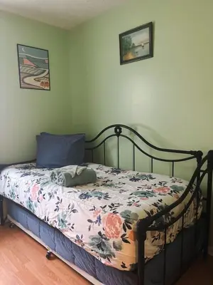 a bedroom with a bed with a floral comforter at Blue Heron Cottage with Game Room, Deck, Hot Tub in Logan