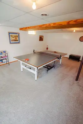 a ping pong table in the middle of a room at Blue Heron Cottage with Game Room, Deck, Hot Tub in Logan
