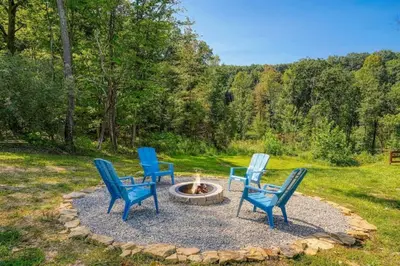 a group of four chairs sitting around a fire pit at Tranquil Heights Cabin in Hocking Hills in Ray