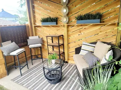 a patio with a couch and chairs and a wooden wall at Joyful Bright1-BR , Fenced Pet Friendly Yard With Garage in Dayton