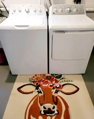 a kitchen with a stove and a cow rug on the floor at Joyful Bright1-BR , Fenced Pet Friendly Yard With Garage in Dayton