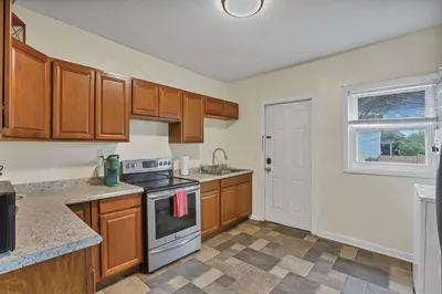 a kitchen with wooden cabinets and a stove top oven at The Rich Street Getaway in Columbus