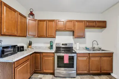 a kitchen with wooden cabinets and a stove top oven at The Rich Street Getaway in Columbus