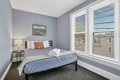 a bedroom with a bed and two windows at The Rich Street Getaway in Columbus