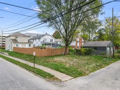 a house with a fence on the side of a street at The Rich Street Getaway in Columbus