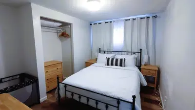 a bedroom with a bed with white sheets and a window at Entire House in Twinsburg in Twinsburg