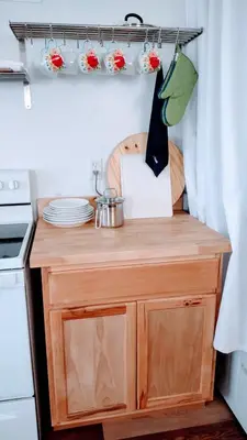 a kitchen with a small wooden cabinet with flowers on it at Entire House in Twinsburg in Twinsburg