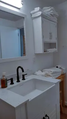 a white kitchen with a sink and a mirror at Entire House in Twinsburg in Twinsburg