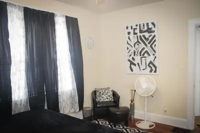 a bedroom with a bed with curtains and a chair at Charming 1 BR Apt 6 miles from Downtown! in Cincinnati