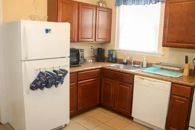 a kitchen with a white refrigerator and wooden cabinets at Charming 1 BR Apt 6 miles from Downtown! in Cincinnati