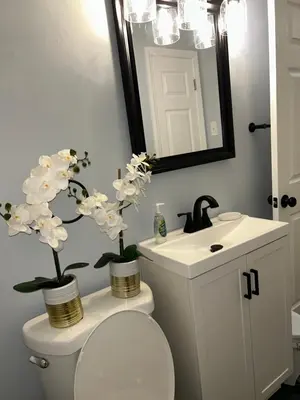 a bathroom with a toilet and a sink with flowers on it at Cozy Apartment 6 miles from Downtown, Cincinnati in Cincinnati