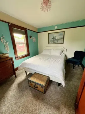 a bedroom with a white bed and a chair at Pendleton Getaway in Pendleton