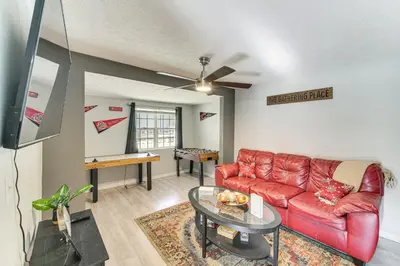 a living room with a red couch and a table at 8 Mi to Dtwn Cleveland Family Home in Cleveland