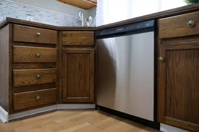 a kitchen with a stainless steel dishwasher and wooden cabinets at Cozy & Convenient Getaway 3BD 2BA Dog Friendly in Akron