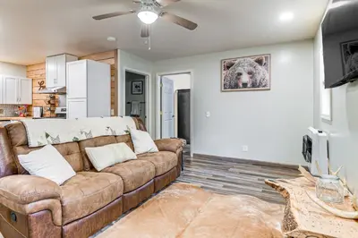 a living room with a couch and a dog on the wall at 1 Mi to Hunting Cozy and Secluded Stout Cabin in Stout