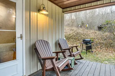 two rocking chairs sitting on a porch with a grill at 1 Mi to Hunting Cozy and Secluded Stout Cabin in Stout