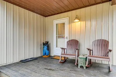 two chairs sitting on the porch of a house at 1 Mi to Hunting Cozy and Secluded Stout Cabin in Stout