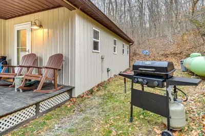 a grill on a porch next to a house at 1 Mi to Hunting Cozy and Secluded Stout Cabin in Stout