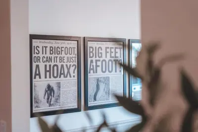 a person looking at framed posters on a wall at Bigfoot's Hideout - A Hocking Hills Escape in Logan