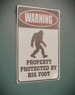 a sign on a wall that reads property protected by a big foot at Bigfoot's Hideout - A Hocking Hills Escape in Logan