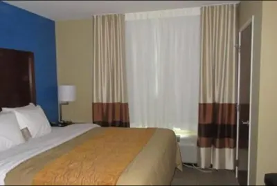 a hotel room with a bed and a window with curtains at Comfort Inn & Suites Caldwell in Caldwell