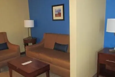 a living room with a brown couch and a blue wall at Comfort Inn & Suites Caldwell in Caldwell