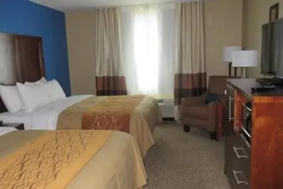 a hotel room with two beds and a television at Comfort Inn & Suites Caldwell in Caldwell