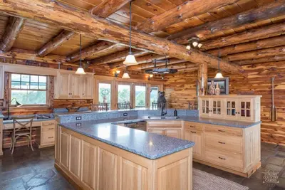 a kitchen with a large island in a log cabin at Stunning Cedar Log Home with Panoramic Views - Hot Tub - Game Bar & Theatre Rooms in Coshocton