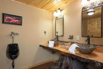 a bathroom with a stone sink and a mirror at Stunning Cedar Log Home with Panoramic Views - Hot Tub - Game Bar & Theatre Rooms in Coshocton