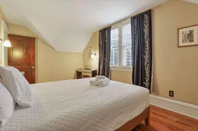 a bedroom with a large white bed with a window at The Orchard Oasis in Columbus