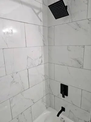a white tiled bathroom with a sink and a shower at Spacious in the heart of it all in Cleveland