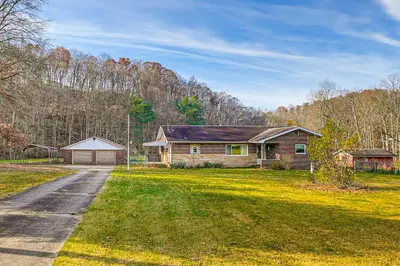a house on a grassy yard with a driveway at Stay and Play West Virginia Country Home! in Davisville