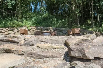 a bunch of rocks and a fire pit in a garden at Stone Lake Lodge - Lakeside Cabin - Stocked Pond in Coshocton