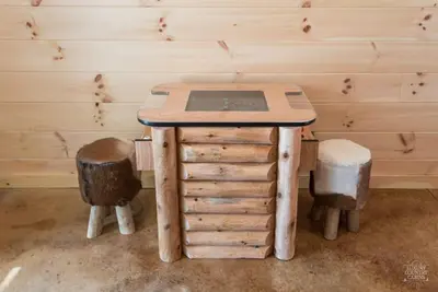a table and two stools in a room at Stone Lake Lodge - Lakeside Cabin - Stocked Pond in Coshocton