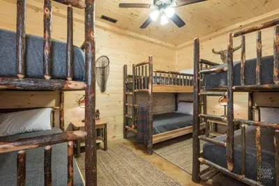 a bedroom with two bunk beds in a cabin at Stone Lake Lodge - Lakeside Cabin - Stocked Pond in Coshocton