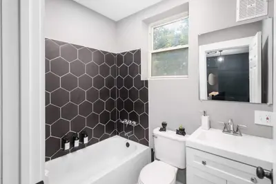 a bathroom with a toilet and a tub and a sink at Modern Luxury in Tremont - 6Bed 3bath Fee parking in Cleveland