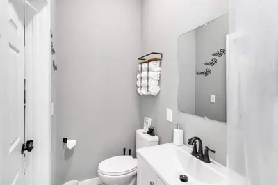 a white bathroom with a toilet and a sink at Modern Luxury in Tremont - 6Bed 3bath Fee parking in Cleveland